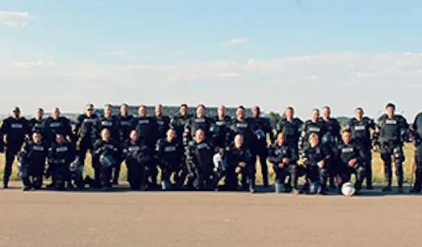 Mobile Field Force team of officers in tactical gear standing on a roadside