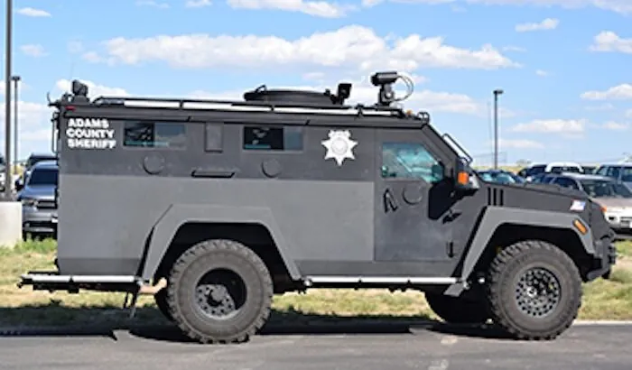 Adams County Sheriff armored SWAT vehicle parked under a cloudy sky