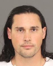 Mugshot of Bruno Hernandez, a man with long dark hair, light skin, and a neutral facial expression, facing the camera directly.