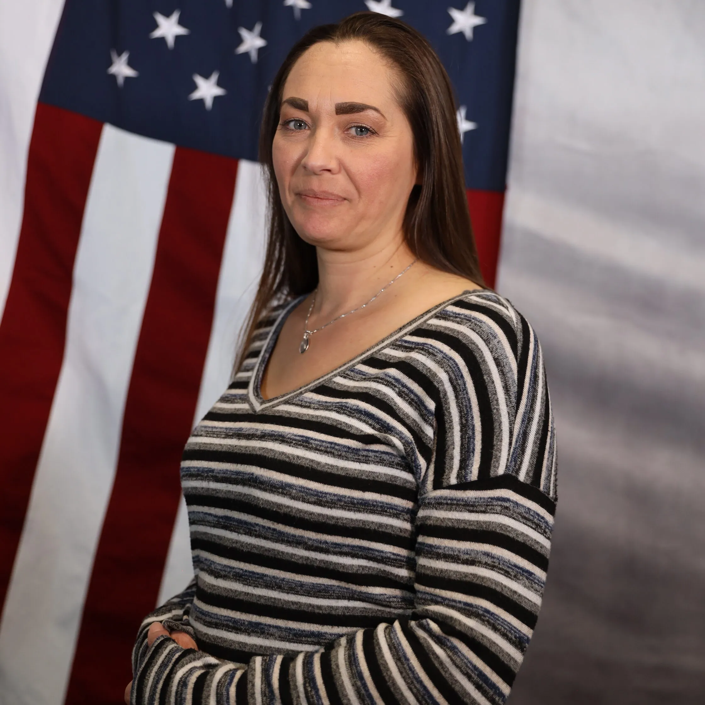 Patrol Executive Nicole Plese standing in front of the American flag.