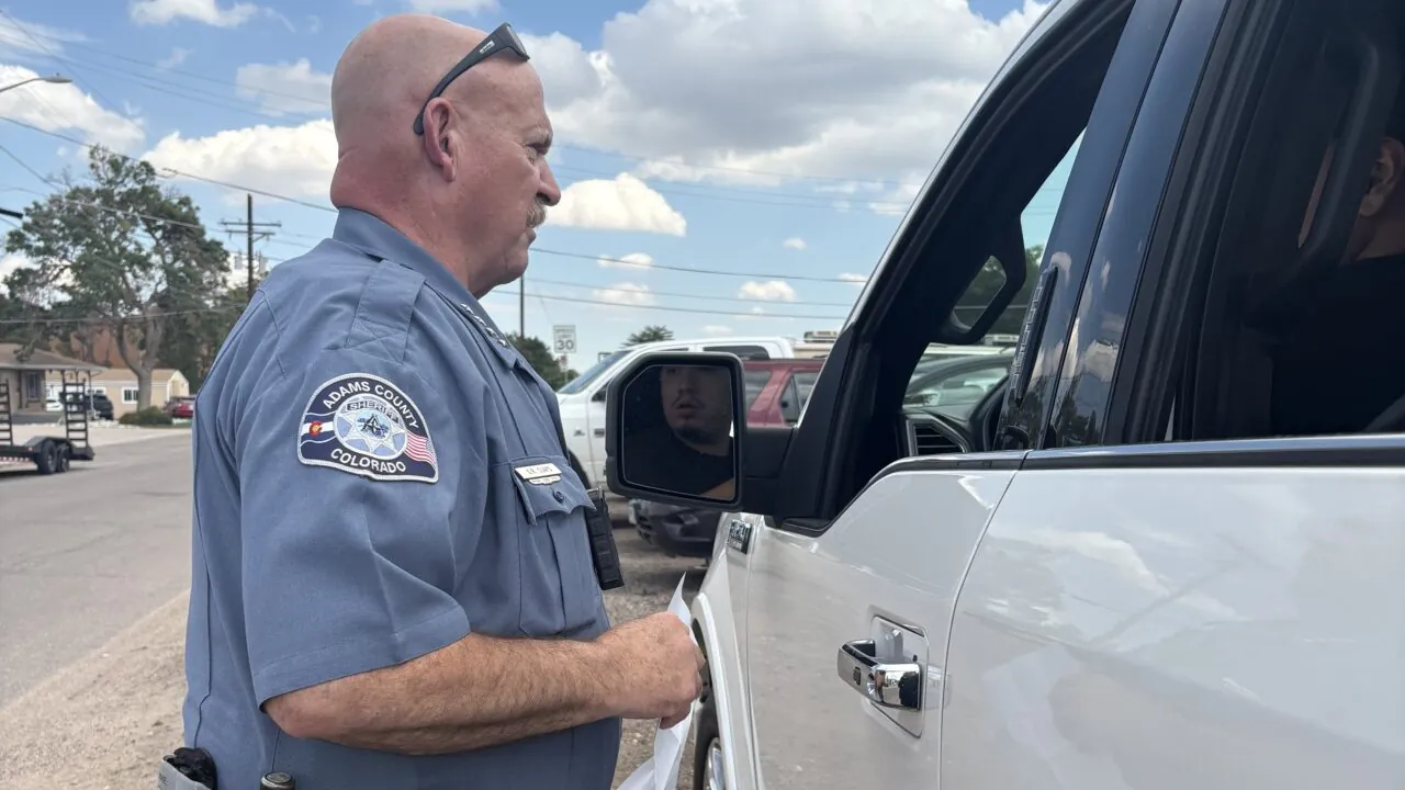 Adams County Colorado Sheriff Gene Claps talking to driver in white vehicle.