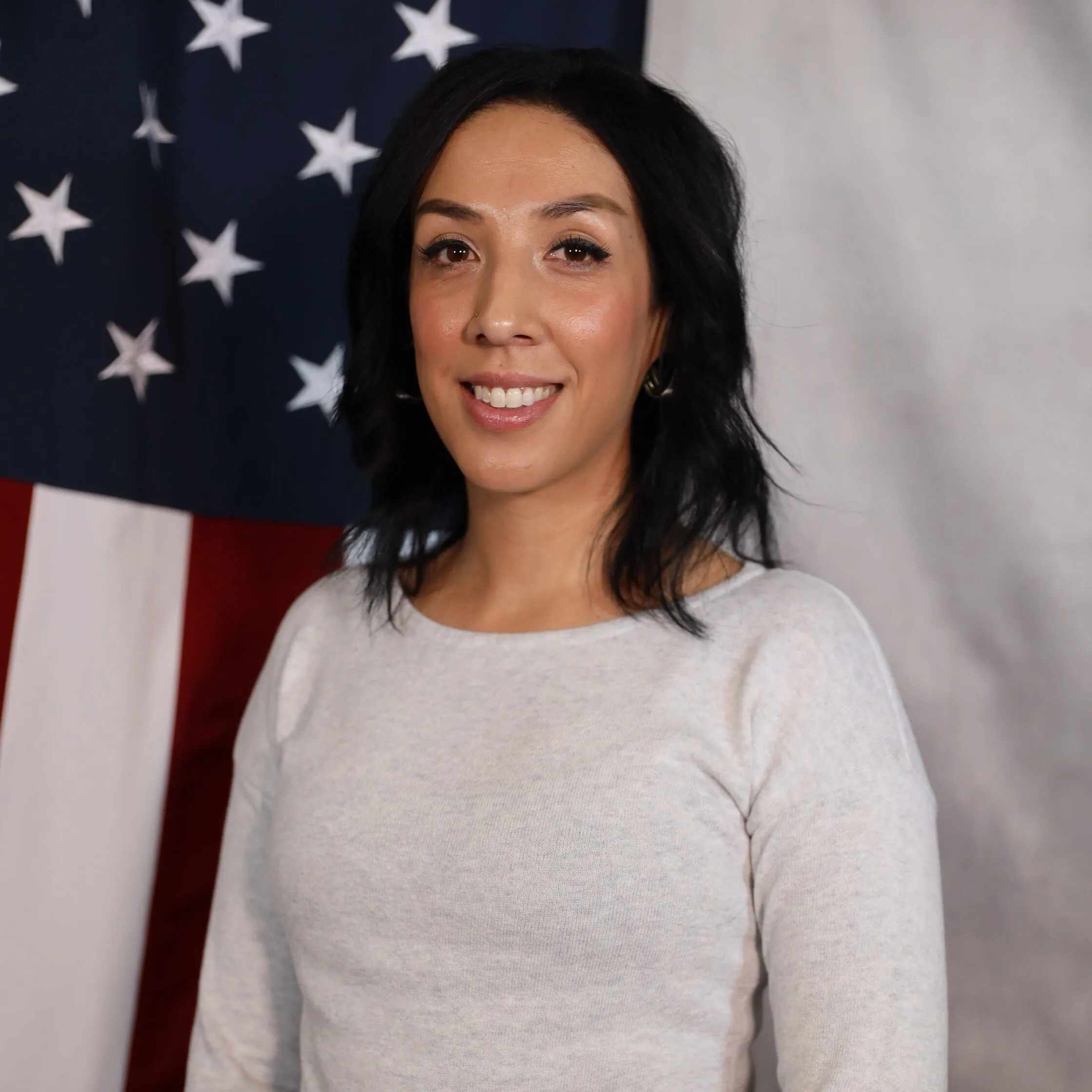Lexi Wooten smiling in front of an American flag