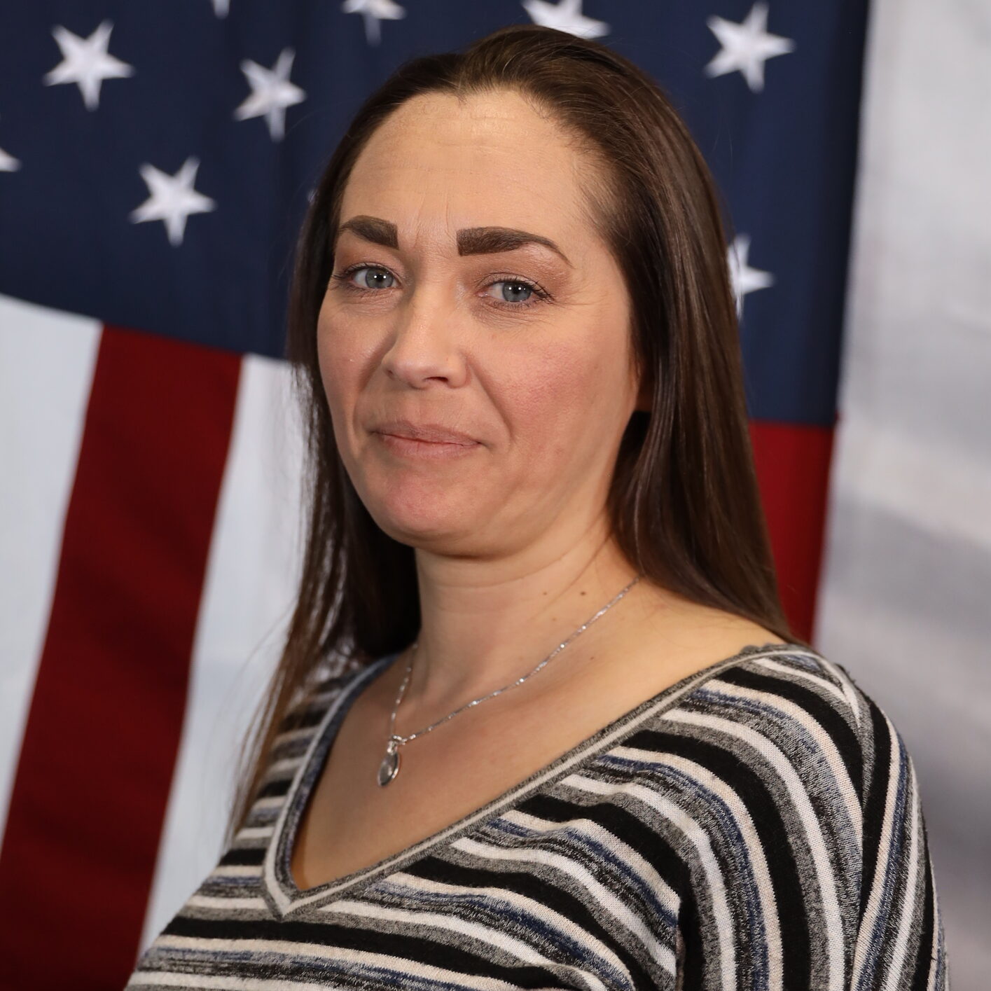 Patrol Executive Nicole Plese standing in front of the American flag.